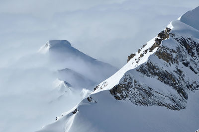 Snow covered high mountains, fog and clouds raising from above. alps, austria