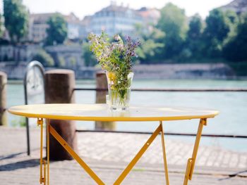 Close-up of empty table and chairs at sidewalk cafe against sky