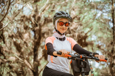 Portrait of young woman wearing sunglasses at park