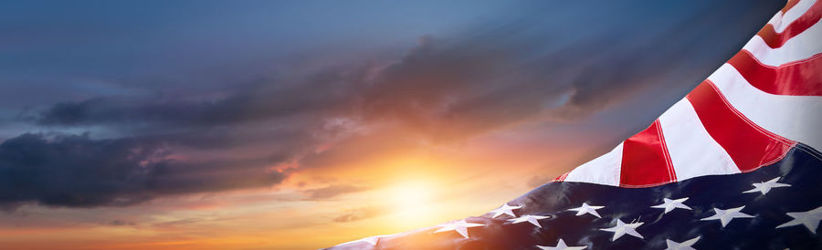 Low angle view of flag against sky during sunset