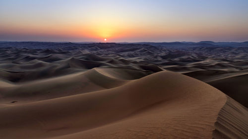 Scenic view of desert against sky during sunset