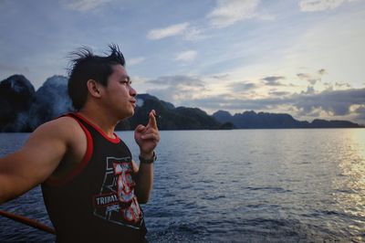 Young woman standing in water against sky
