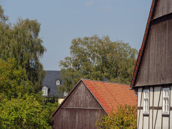 Old house amidst trees and plants against sky