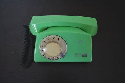 High angle view of green rotary phone on table