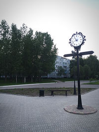 Street amidst trees in park against clear sky