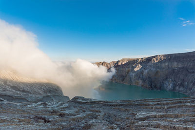 Scenic view of lake and mountains against blue sky