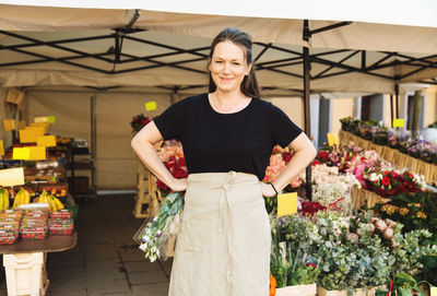 Portrait of confident female owner standing at flower shop