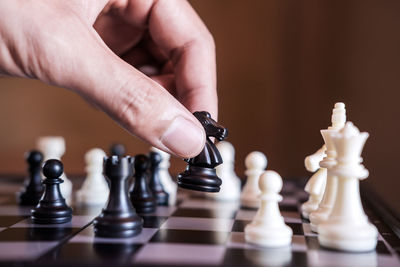 Cropped hand of person playing chess