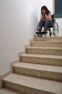 Rear view of man sitting on staircase