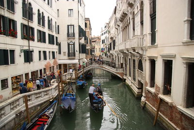 Gondola on canal amidst buildings in city