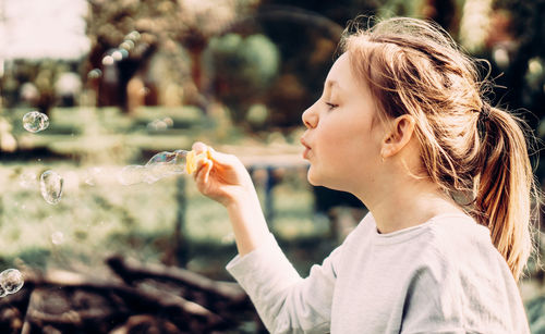 Side view portrait of girl holding outdoors