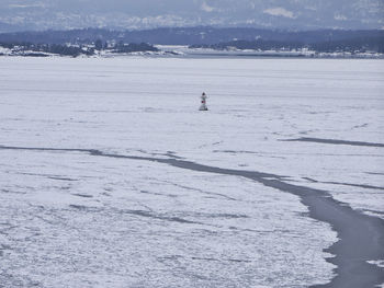 Mid distance view of lighthouse on frozen sea