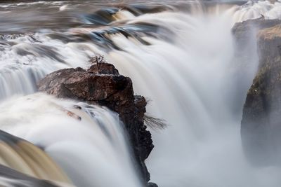 Close-up of waterfall against rocks in sea