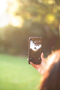 Close-up of man holding mobile phone outdoors