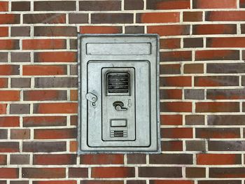 Close-up of telephone on brick wall