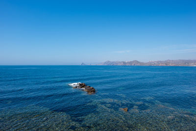 Scenic view of sea against clear blue sky