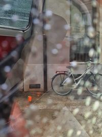 Bicycle on street seen through glass window