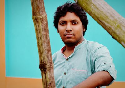 Portrait of young man standing against wall