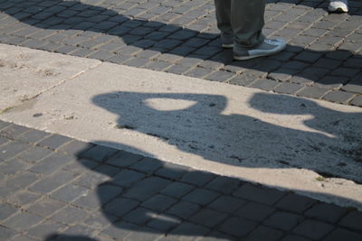 Low section of person shadow on tiled floor