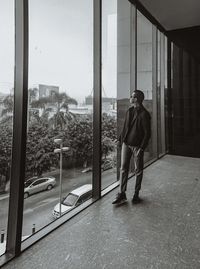 Rear view of man standing by window