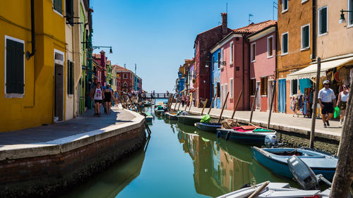 Boats in canal amidst buildings in city