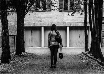 Rear view of woman standing on road