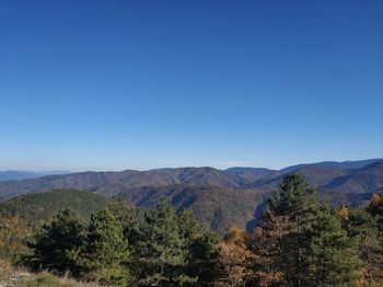 Scenic view of mountains against clear blue sky