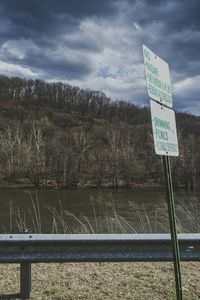 Road sign against cloudy sky