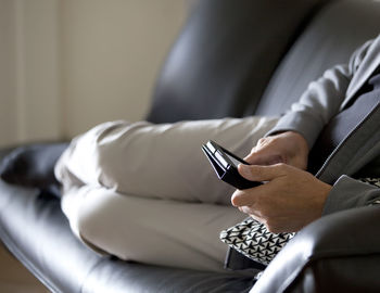 Midsection of man using mobile phone