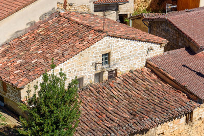 Background of old village houses with stone walls and red tile roofs.