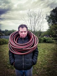 Portrait of man with garden hose around neck