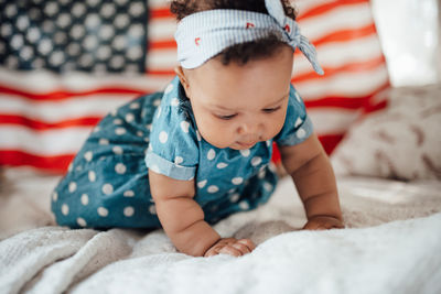 Midsection of baby girl lying on bed