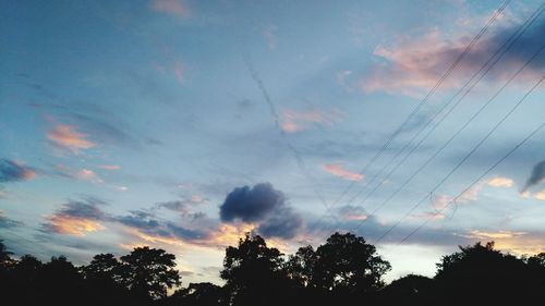 Low angle view of silhouette trees against sky