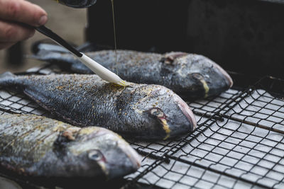 Cooking sea fish. raw dorado fish with spices on bbq mesh.