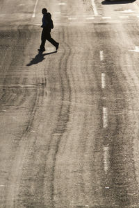 Full length of silhouette man walking on road