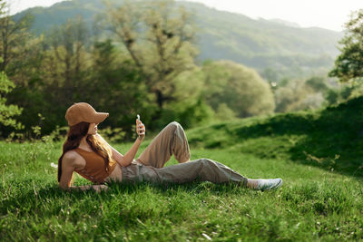 Rear view of woman sitting on grassy field