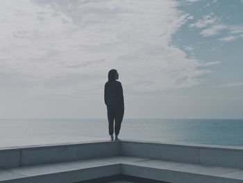 Woman standing by sea