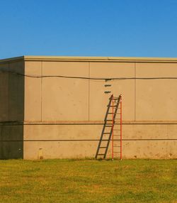 Built structure on field against clear blue sky