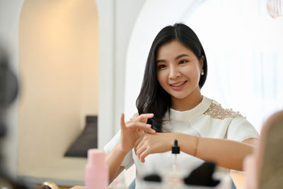 Portrait of smiling young woman using mobile phone