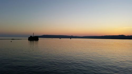 Boat in sea at sunset