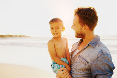 Father and son standing at beach