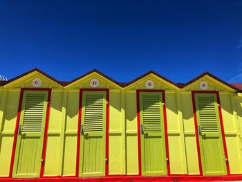 Low angle view of beach house against clear blue sky