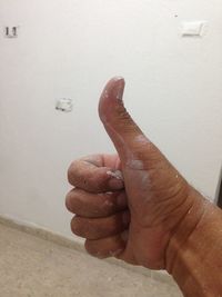 Close-up of person hand on wet wall