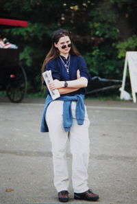 Portrait of young woman wearing sunglasses while standing on street