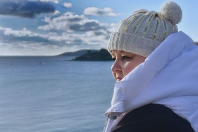 Portrait of young woman standing at beach