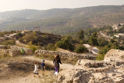Rear view of people walking on mountain