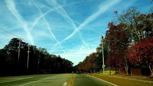 Road amidst trees against sky