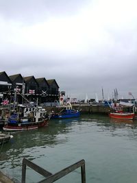 Boats moored in sea against sky