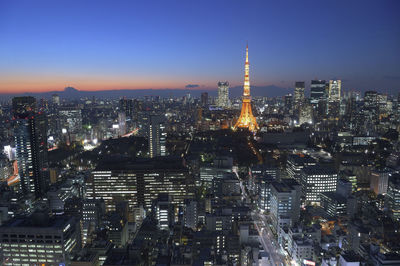 Illuminated cityscape against sky at night