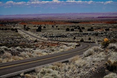  desertan open road curves through the painted desert wilderness to the horizon in arizona.